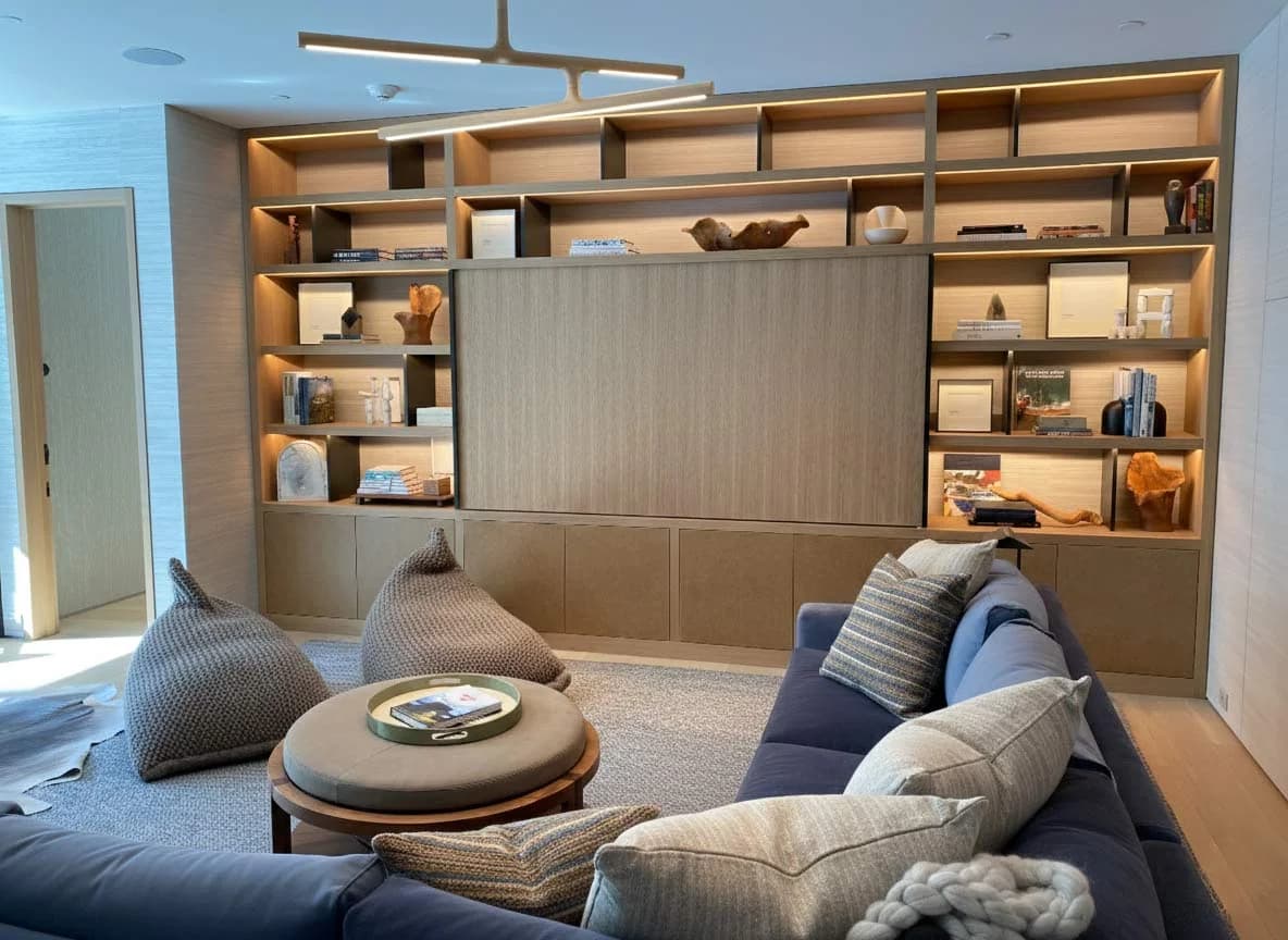 Custom built-in entertainment center with backlit shelving and hidden TV panel